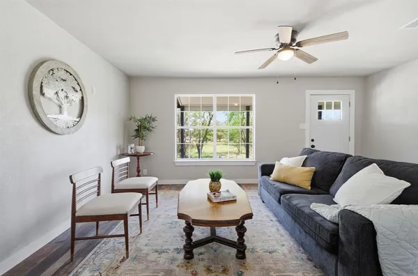 a living room with furniture a clock and a window
