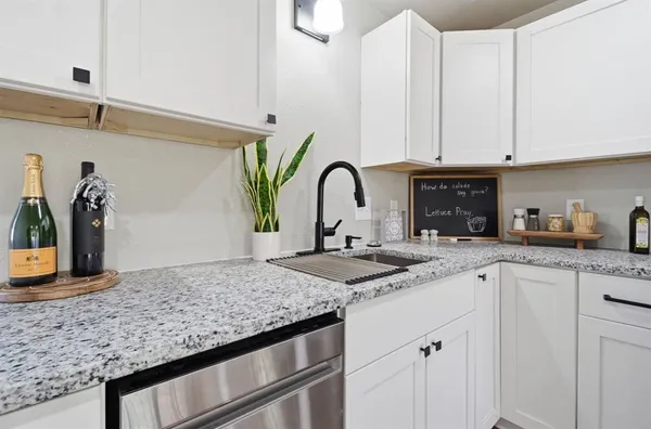 a kitchen with granite countertop a sink white cabinets and a granite counter tops