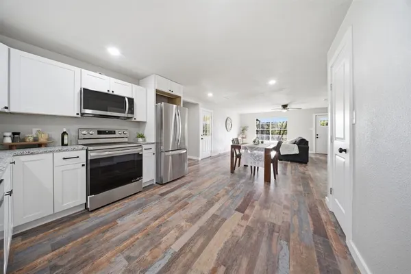 a kitchen with a table chairs a stove and a microwave
