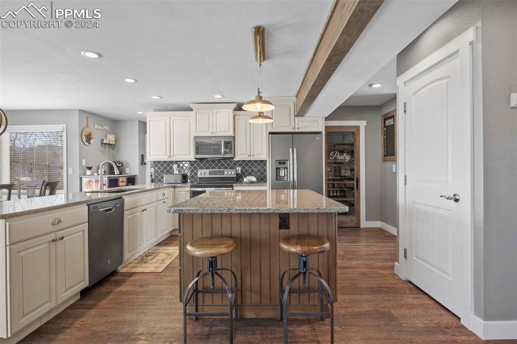 3815 Sierra Vista Road Monument, CO 80132 - Photo 11 of 44 a large kitchen with kitchen island a dining table and chairs