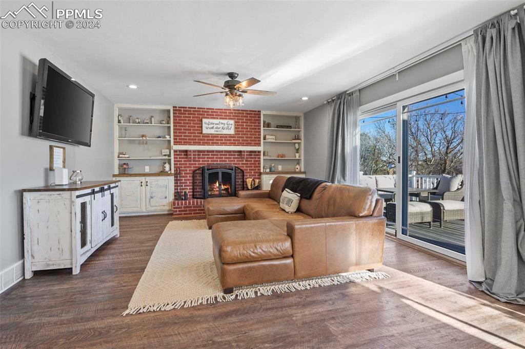 3815 Sierra Vista Road Monument, CO 80132 - Photo 13 of 44 a living room with furniture a flat screen tv and a fireplace