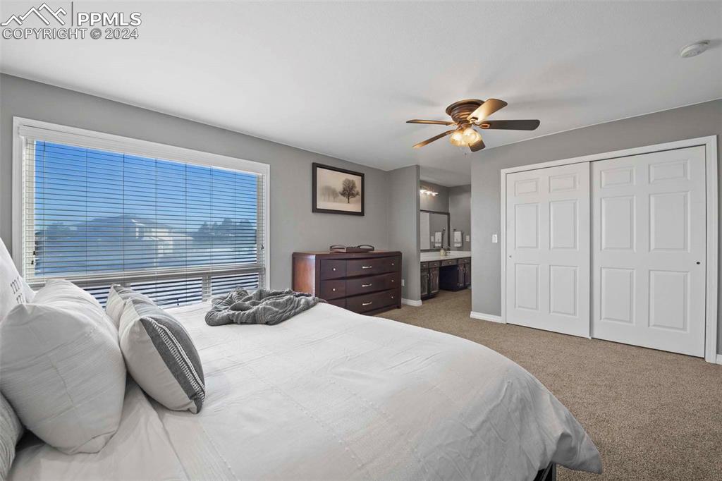 3815 Sierra Vista Road Monument, CO 80132 - Photo 19 of 44 a bedroom with a bed and a chandelier