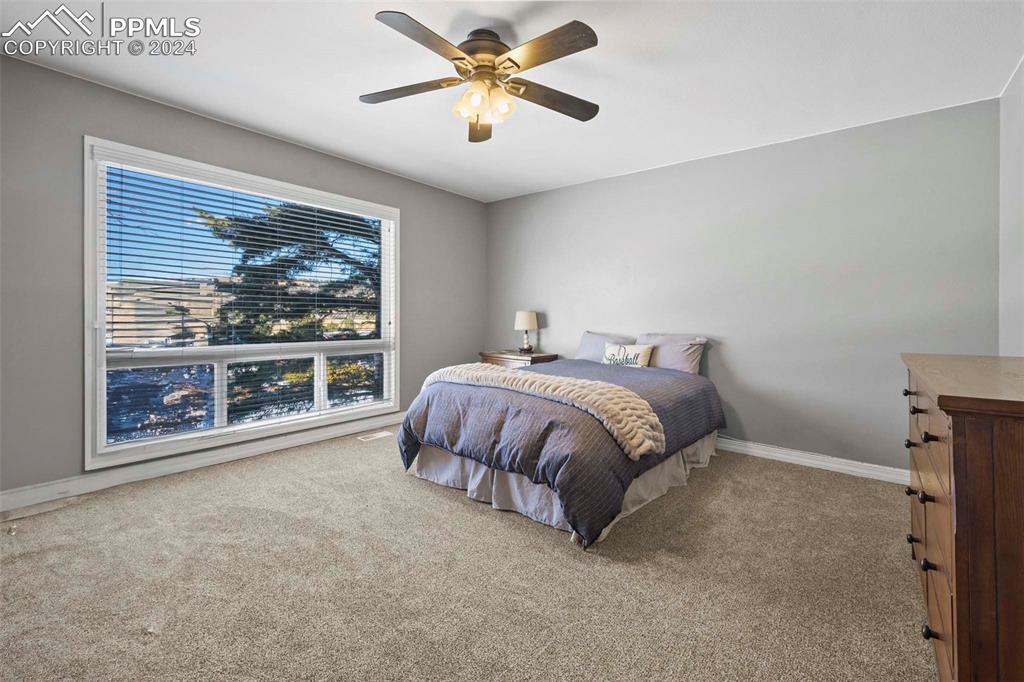 3815 Sierra Vista Road Monument, CO 80132 - Photo 24 of 44 a spacious bedroom with a bed and a painting on the wall