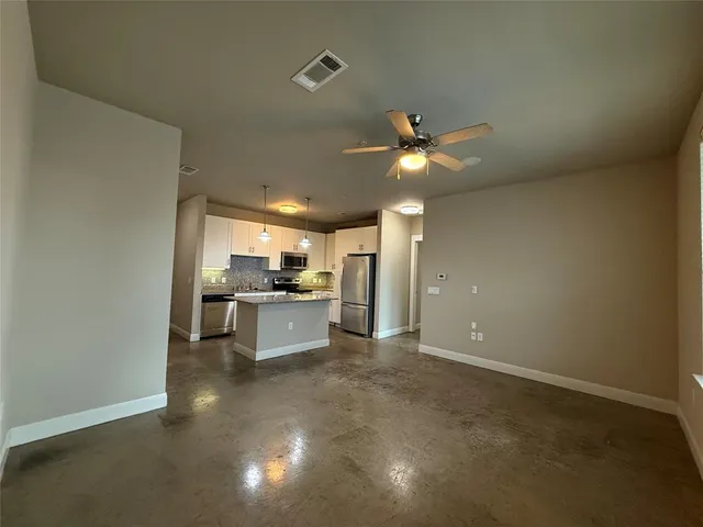 a view of a kitchen with a sink and a refrigerator