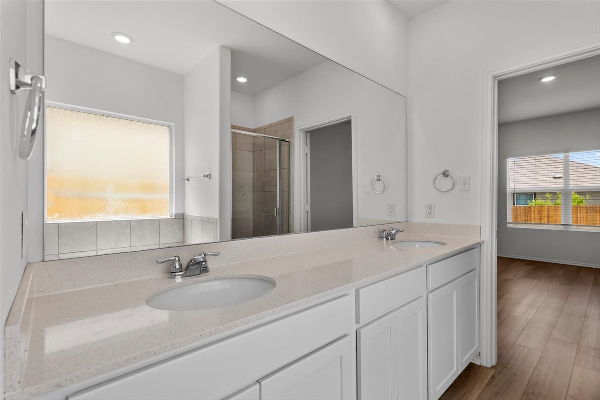 448 Perfect World Loop Jarrell, TX 76537 - Photo 29 of 40 Double vanity with stone counters provides ample space in this bright bathroom.