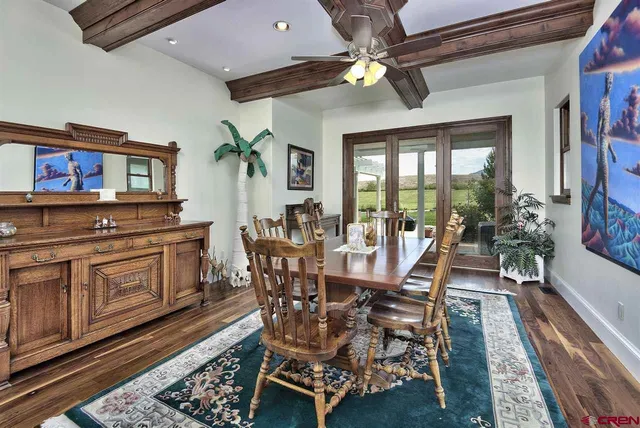 a dining room with wooden floor a chandelier a wooden table and chairs