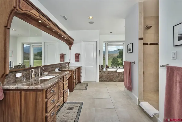 a bathroom with sink shower and mirror