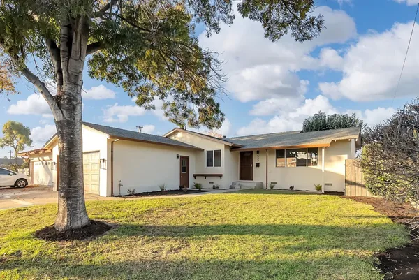 a front view of house with yard and trees around