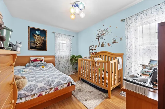 a bedroom with a bed a chandelier and dresser