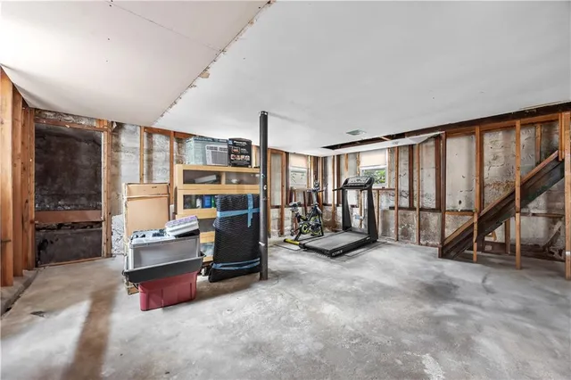a living room with furniture gym equipment and a large window