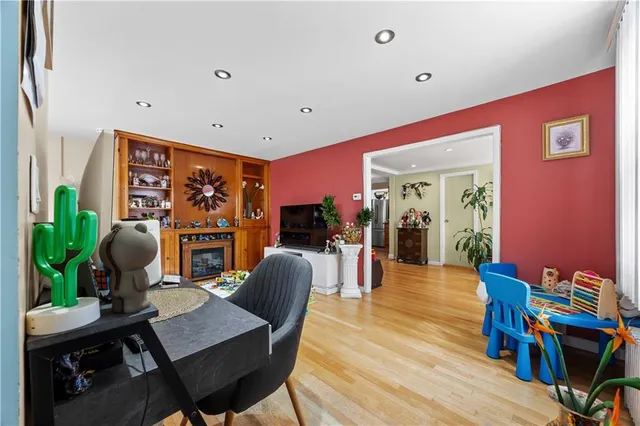 a dining room with furniture a potted plant and wooden floor
