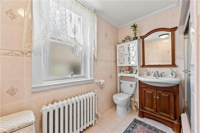 a bathroom with a granite countertop sink mirror vanity and toilet