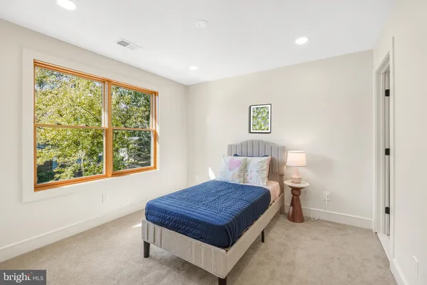 a bed sitting in a spacious bedroom next to a window