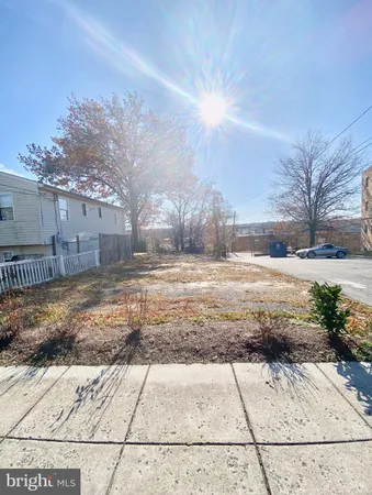a view of a yard with wooden fence