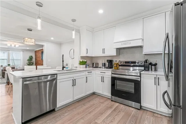 a kitchen with cabinets stainless steel appliances and a sink