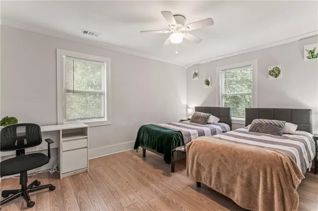 a bedroom with two beds and a potted plant