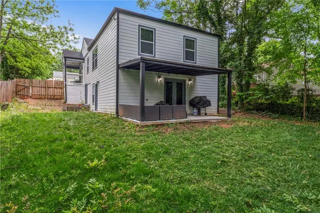 a view of a house with backyard and sitting area