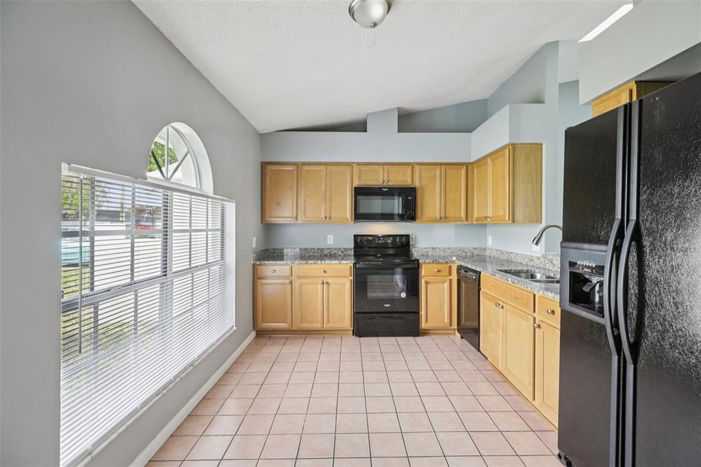 734 Bittern Lane Kissimmee, FL 34759 - Photo 14 of 55 a kitchen with stainless steel appliances granite countertop a refrigerator and a stove top oven