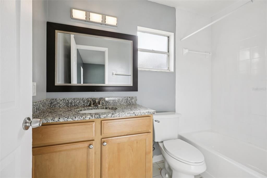 734 Bittern Lane Kissimmee, FL 34759 - Photo 19 of 55 a bathroom with a toilet sink vanity and mirror