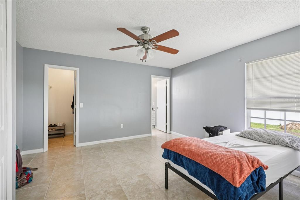 734 Bittern Lane Kissimmee, FL 34759 - Photo 28 of 55 a bedroom with a bed and a chandelier