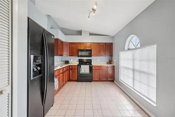 a kitchen with stainless steel appliances granite countertop a refrigerator and a sink