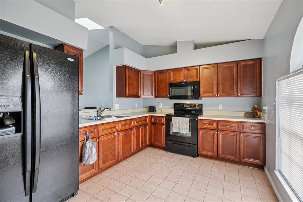 734 Bittern Lane Kissimmee, FL 34759 - Photo 45 of 55 a kitchen with stainless steel appliances granite countertop a refrigerator and a stove top oven