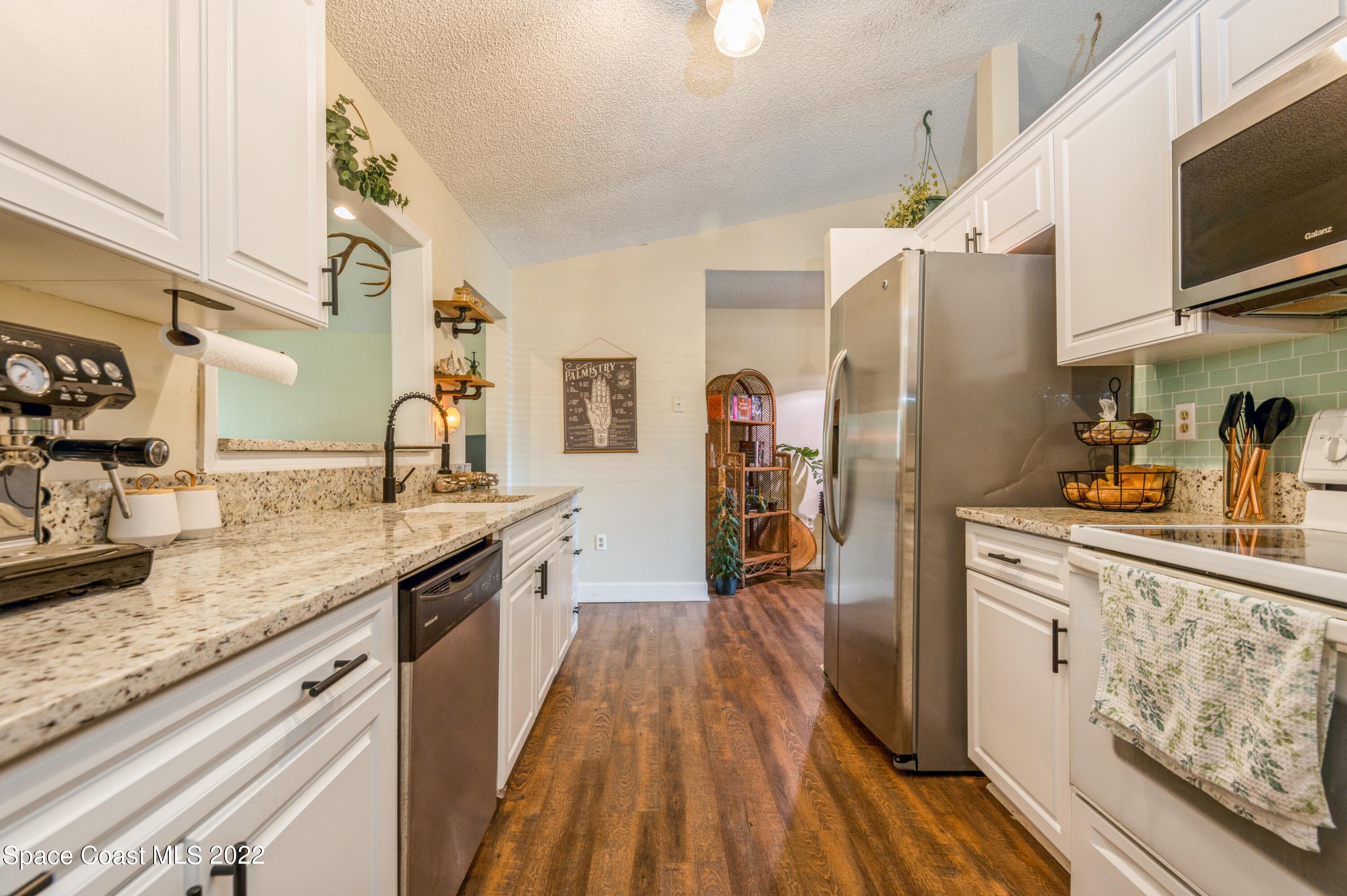 6480 Hudson Road Cocoa, FL 32927 - Photo 9 of 24 a kitchen with stainless steel appliances granite countertop a lot of counter space and wooden floor