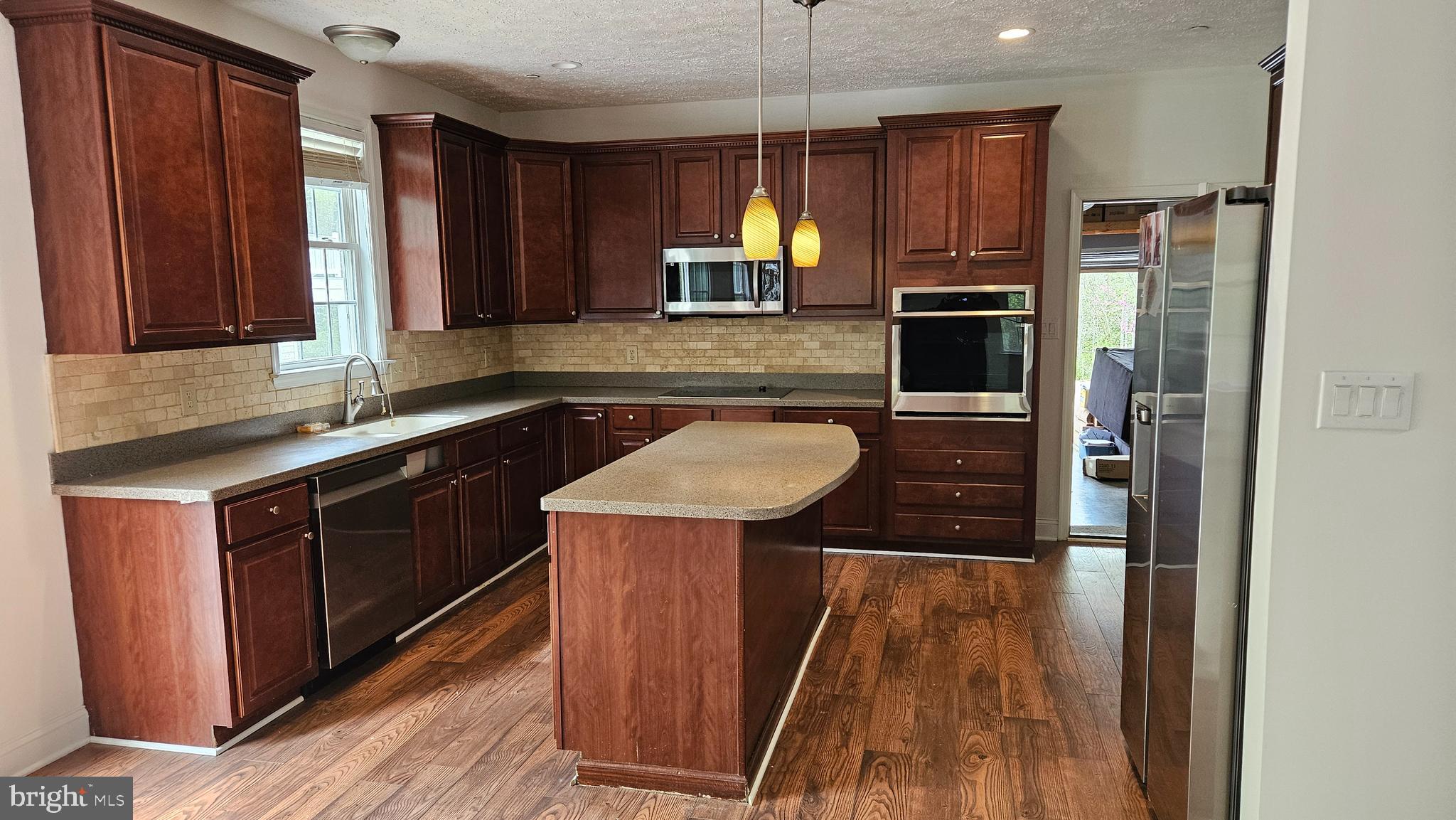 10495 Green Leaf Place La Plata, MD 20646 - Photo 6 of 24 a kitchen with wooden cabinets a sink a stove a refrigerator and island with wooden floor