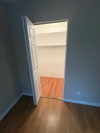 an empty room with wooden floor and closet