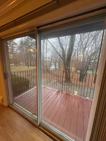 a view of a room with wooden floor and floor to ceiling window