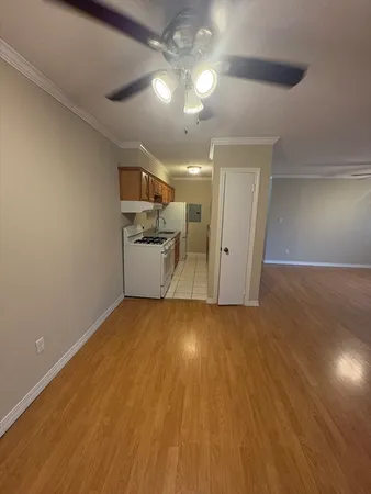 wooden floor in an empty room with a kitchen