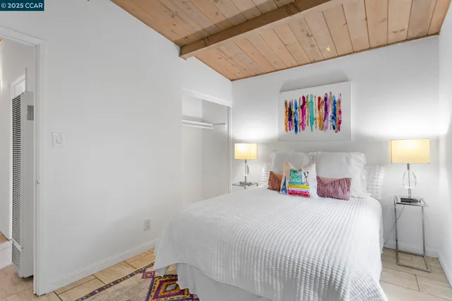 a bedroom with a bed and a lamp on dresser