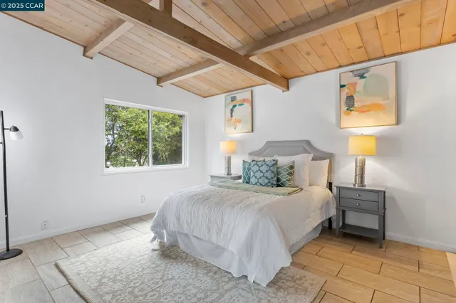 a bedroom with a bed and a lamp on the dresser