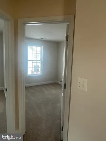 a view of an empty room with wooden floor and entryway