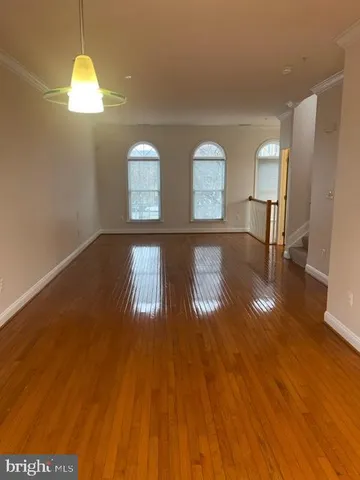 a view of a livingroom with wooden floor and windows