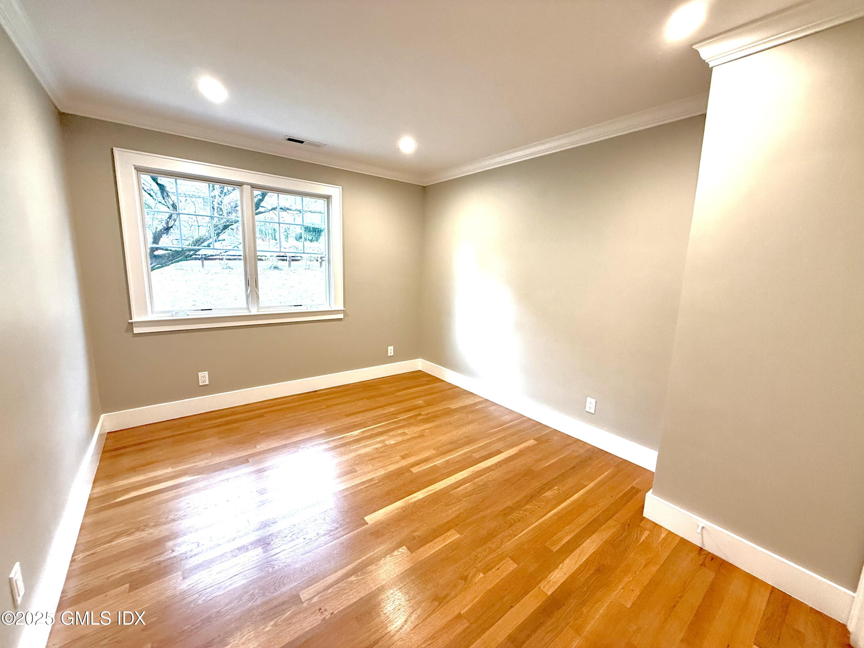 79 Laddins Rock Road Old Greenwich, CT 06870 - Photo 12 of 26 a view of an empty room with wooden floor and a window