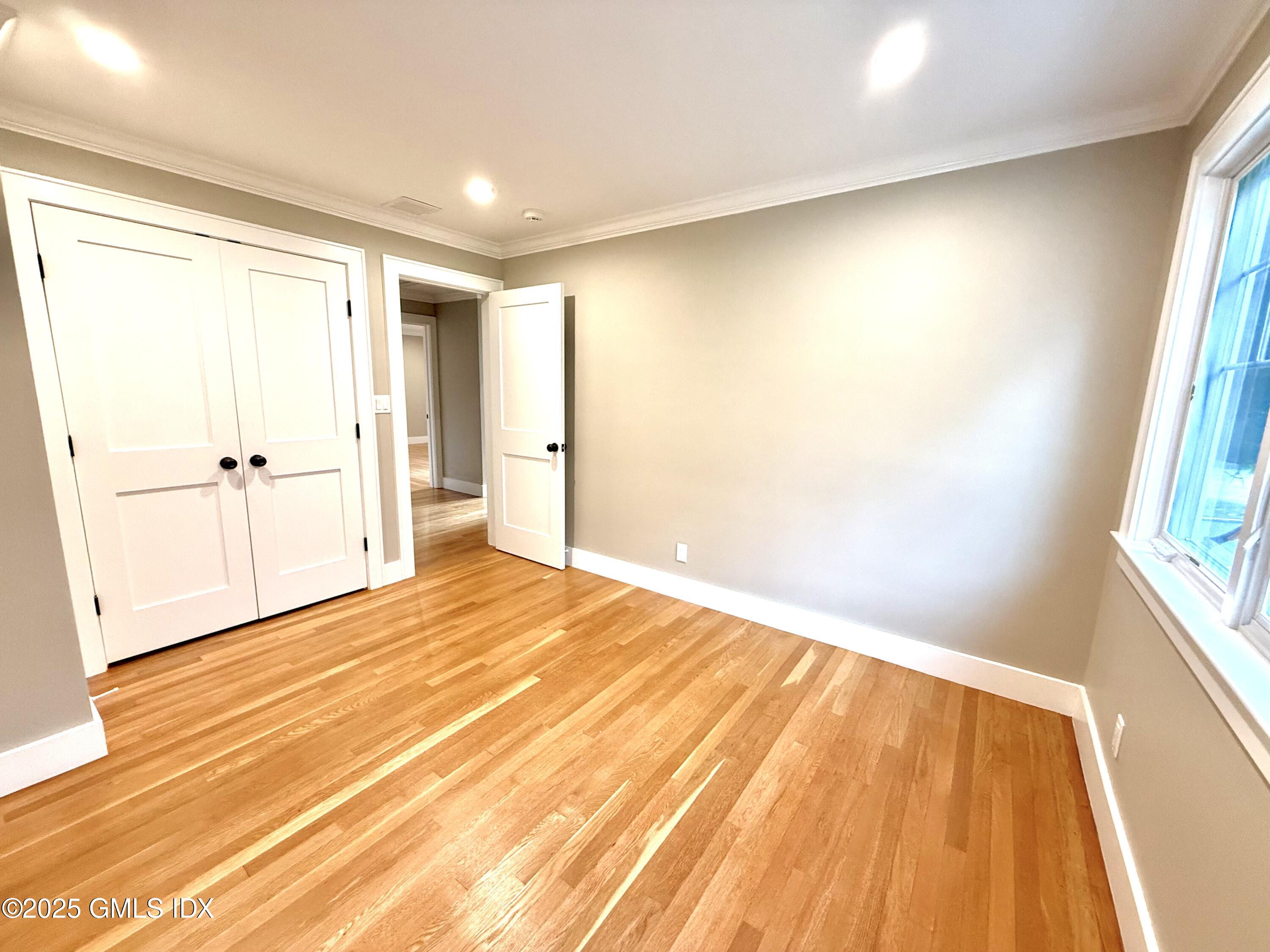 79 Laddins Rock Road Old Greenwich, CT 06870 - Photo 13 of 26 a view of an empty room with wooden floor and a window