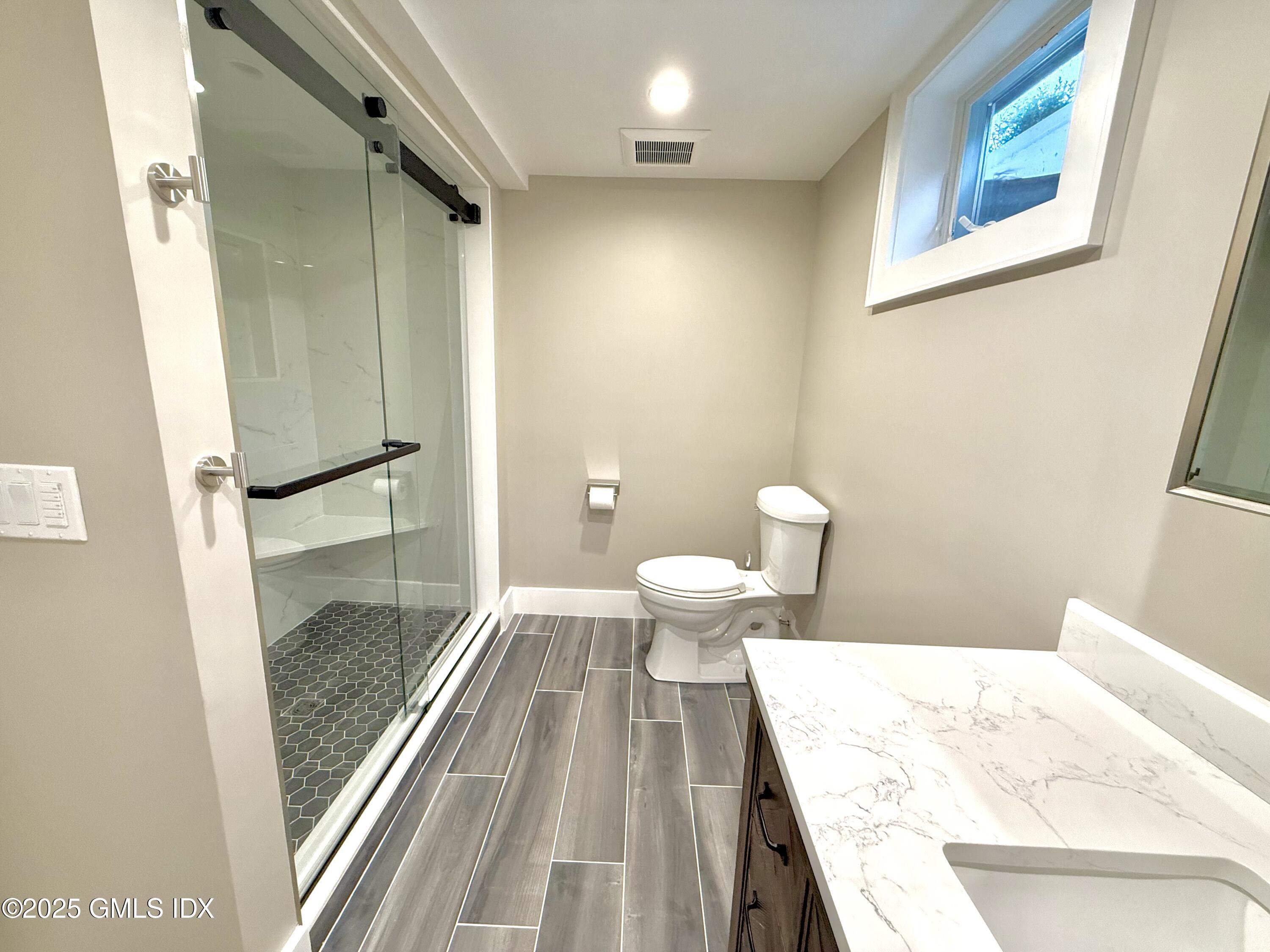 79 Laddins Rock Road Old Greenwich, CT 06870 - Photo 20 of 26 a bathroom with a granite countertop sink a toilet and shower