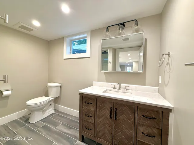 a bathroom with a sink mirror vanity and a toilet