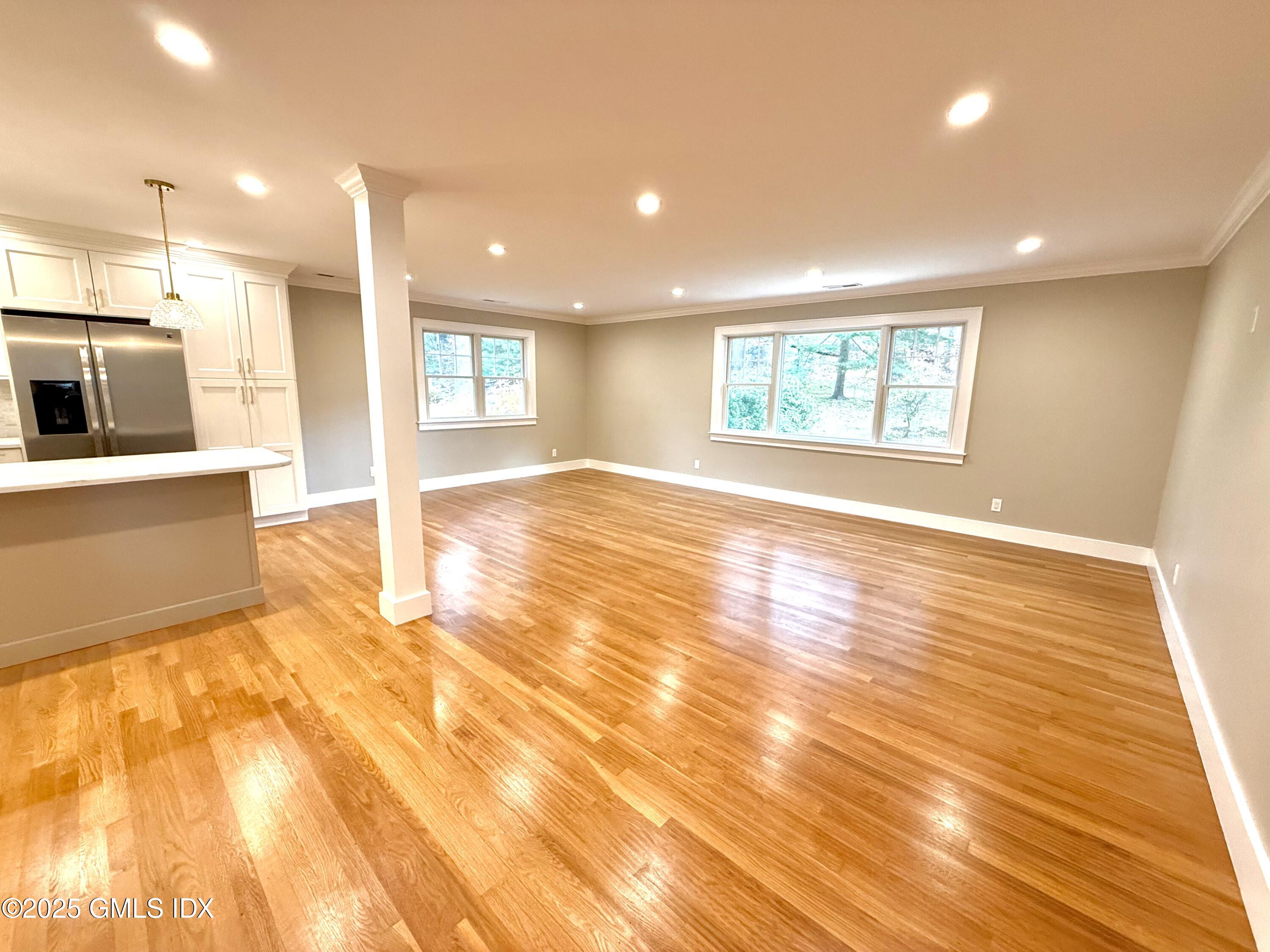 79 Laddins Rock Road Old Greenwich, CT 06870 - Photo 7 of 26 a view of an empty room with wooden floor and a kitchen