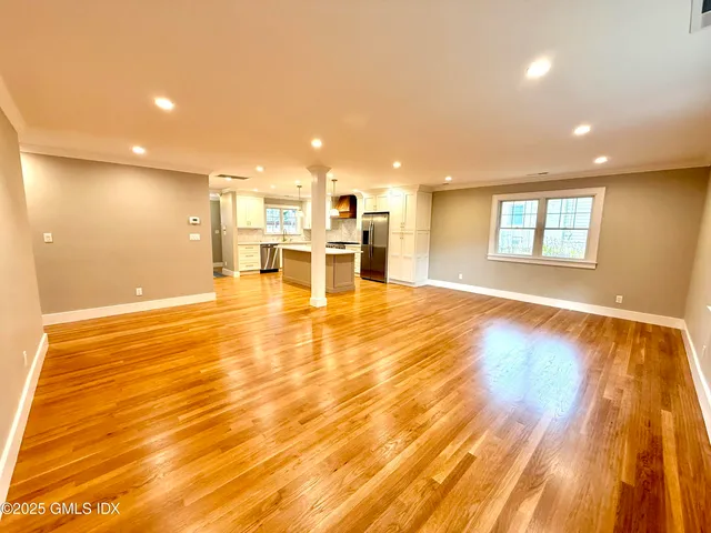 a view of a living room a dining room with wooden floor and a window