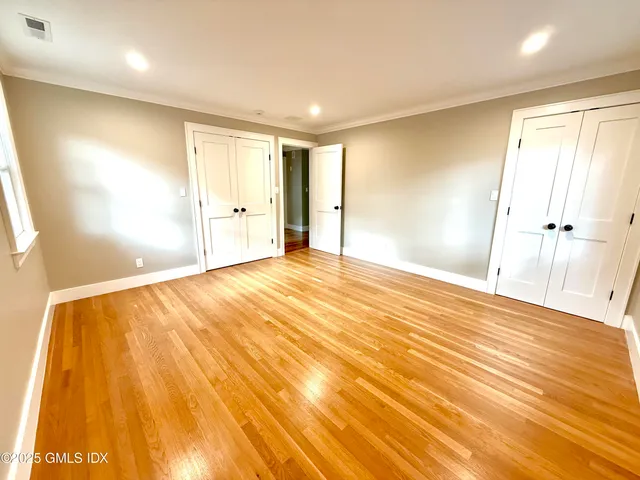 a view of an empty room with wooden floor