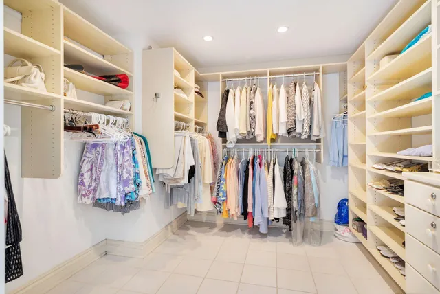 a view of walk in closet with clothes and shoes
