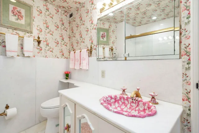 a bathroom with a sink a toilet and a mirror