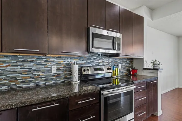 a kitchen with stainless steel appliances granite countertop a stove a microwave and cabinets