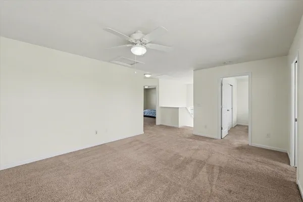 an empty room with a ceiling fan and entryway