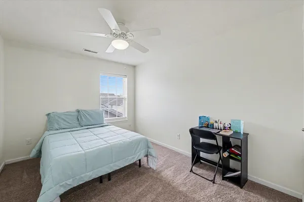 a bedroom with a bed and a chair in it