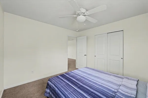 a bedroom with a bed and a ceiling fan