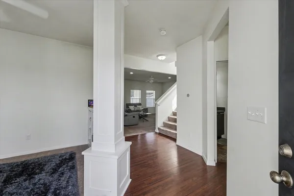 a view of a hallway with wooden floor fireplace and living room