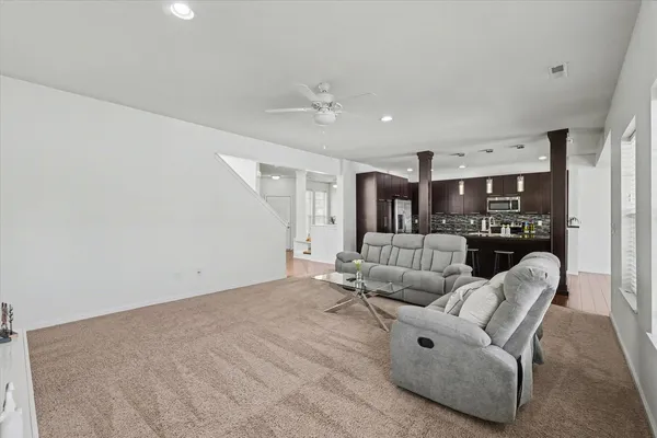 a living room with furniture and kitchen view